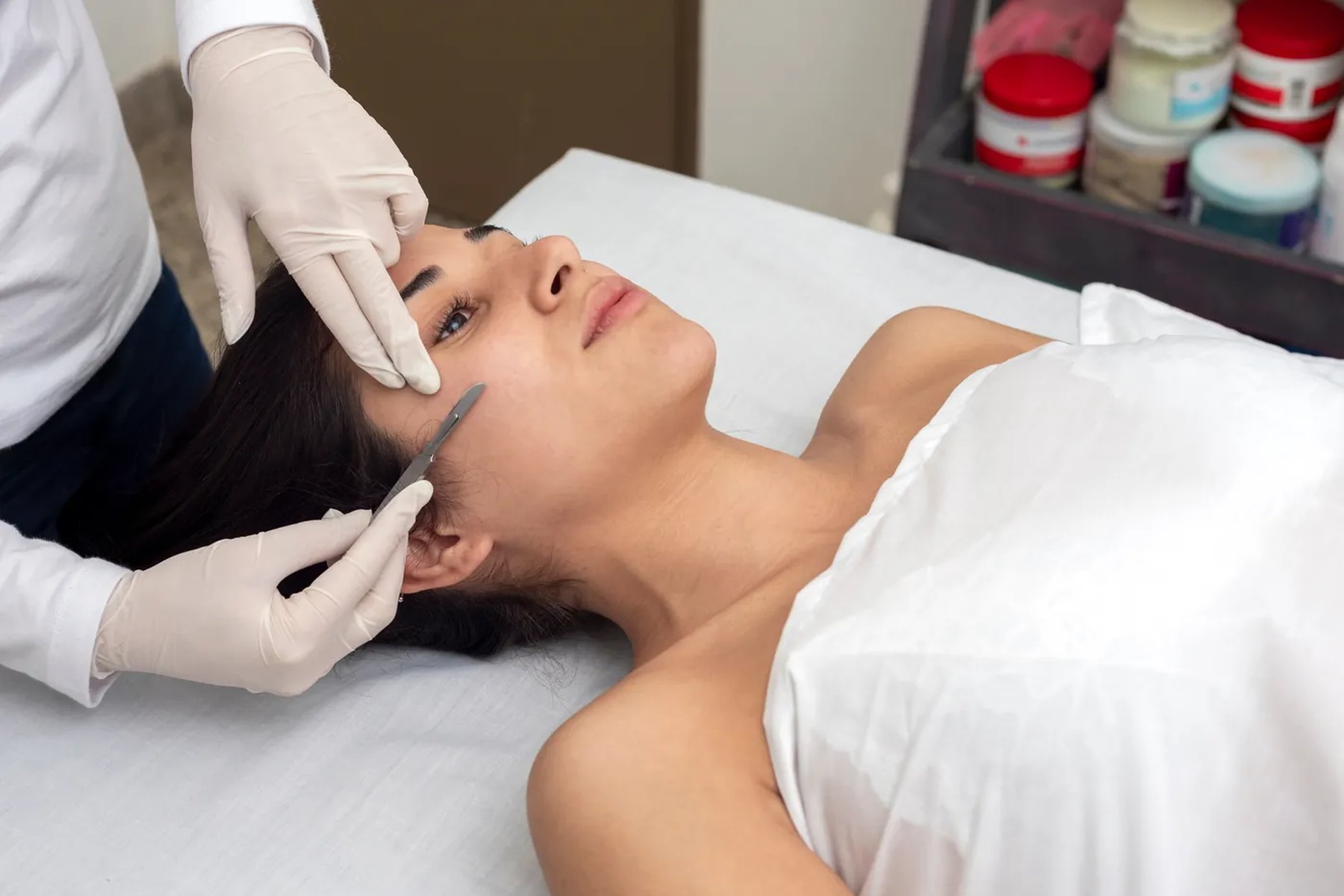 Esthetician performing a gentle exfoliating facial treatment on a client